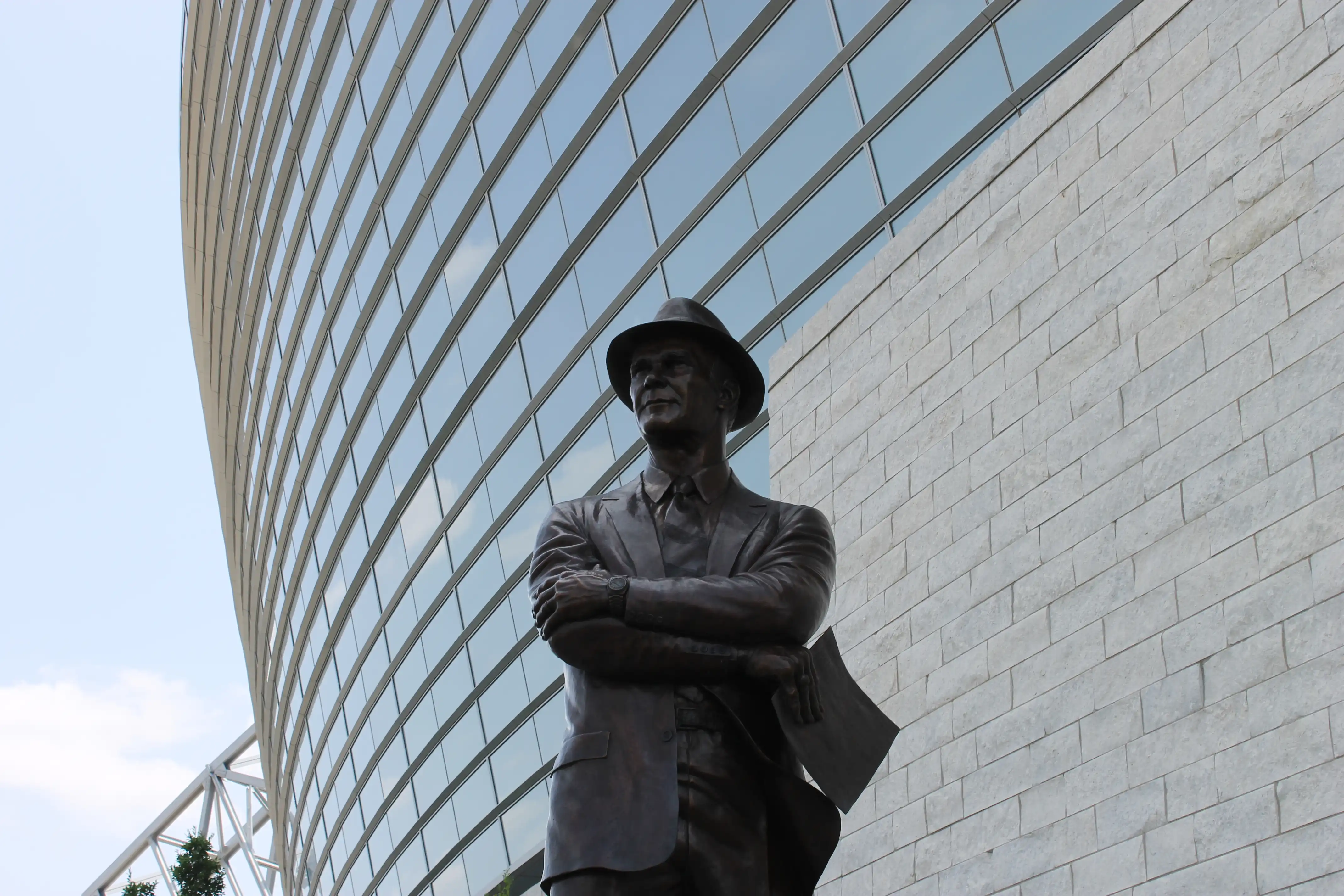 Statue of a man crossing arms in front of a building