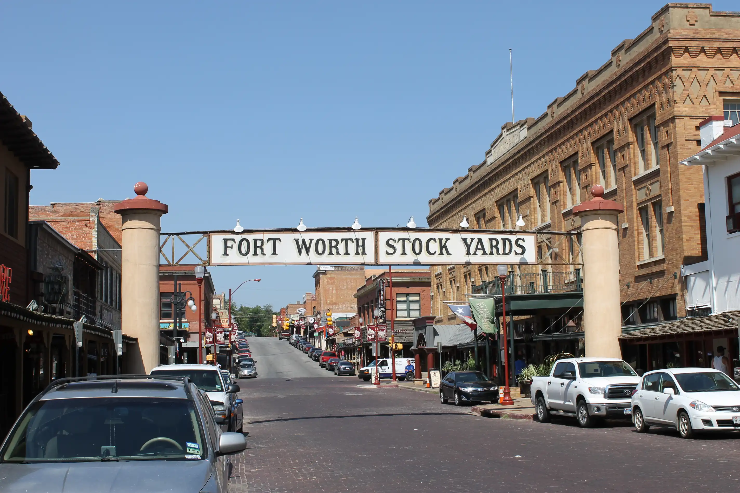 A sign reading 'Fort Worth Stock Yards' over an old main street