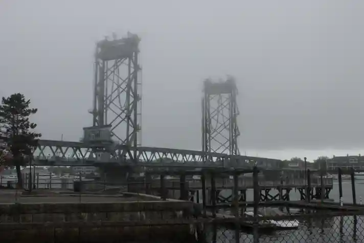 An industrial looking bridge partly shrouded in fog