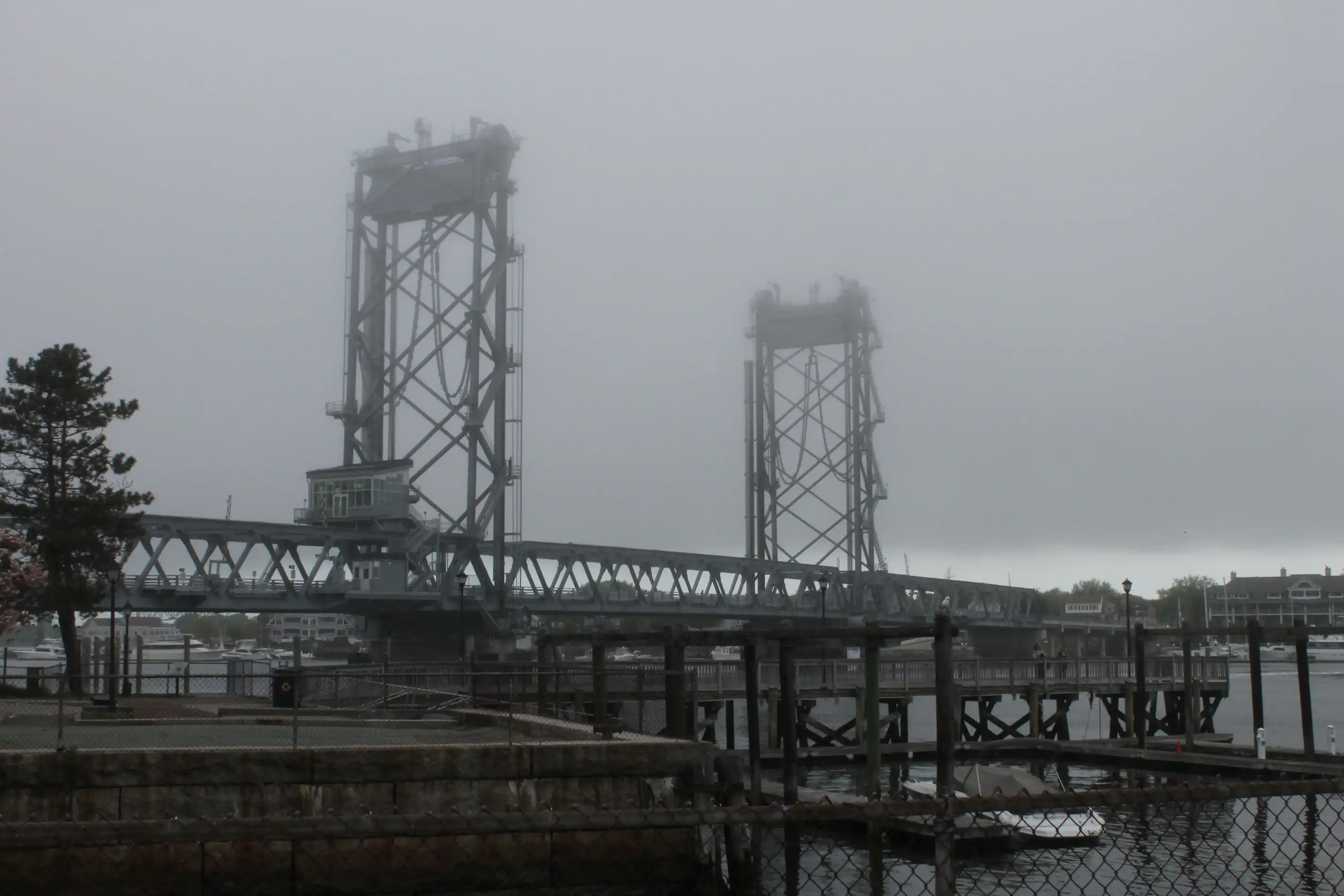 An industrial looking bridge partly shrouded in fog