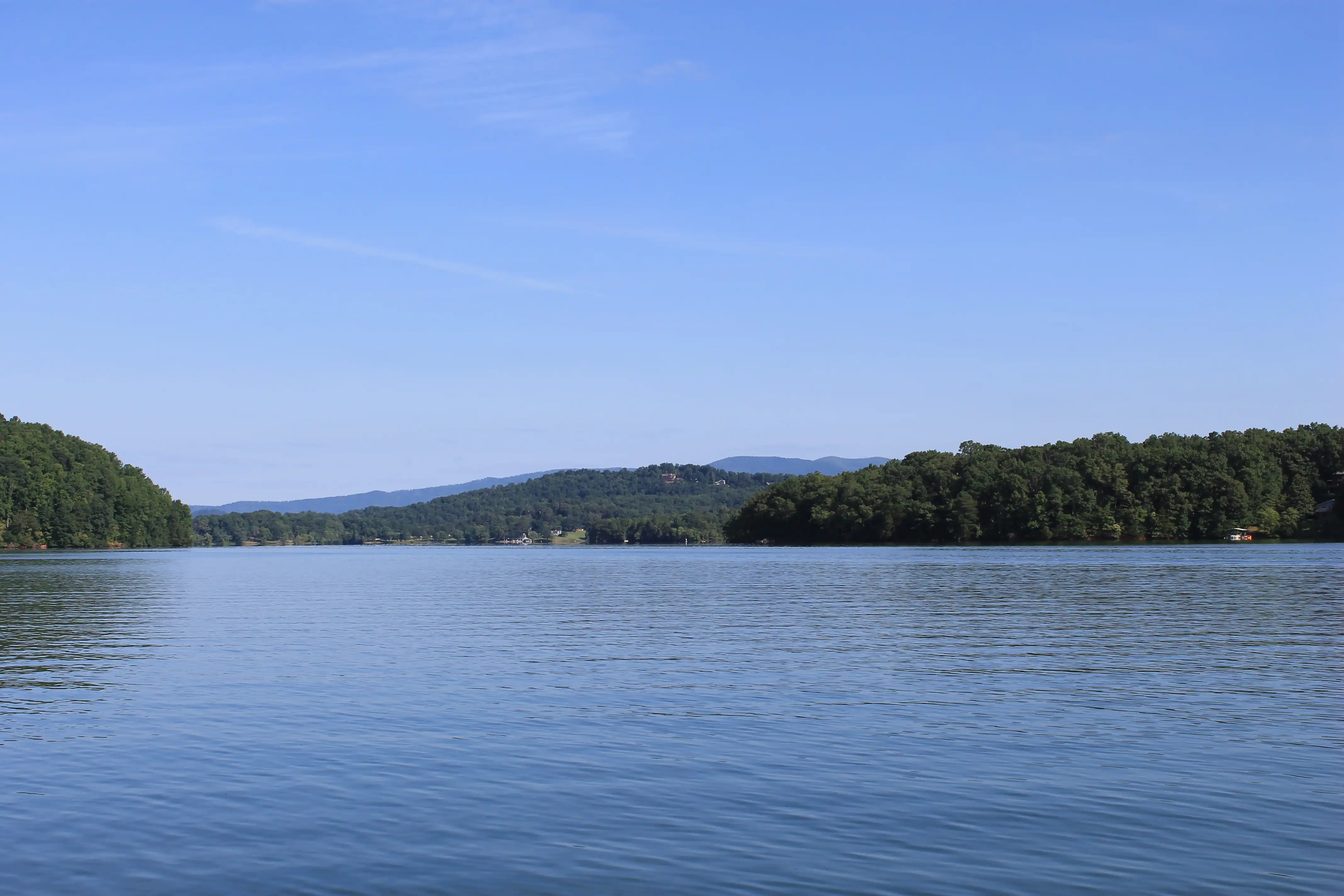 A lake with forested hills in the background