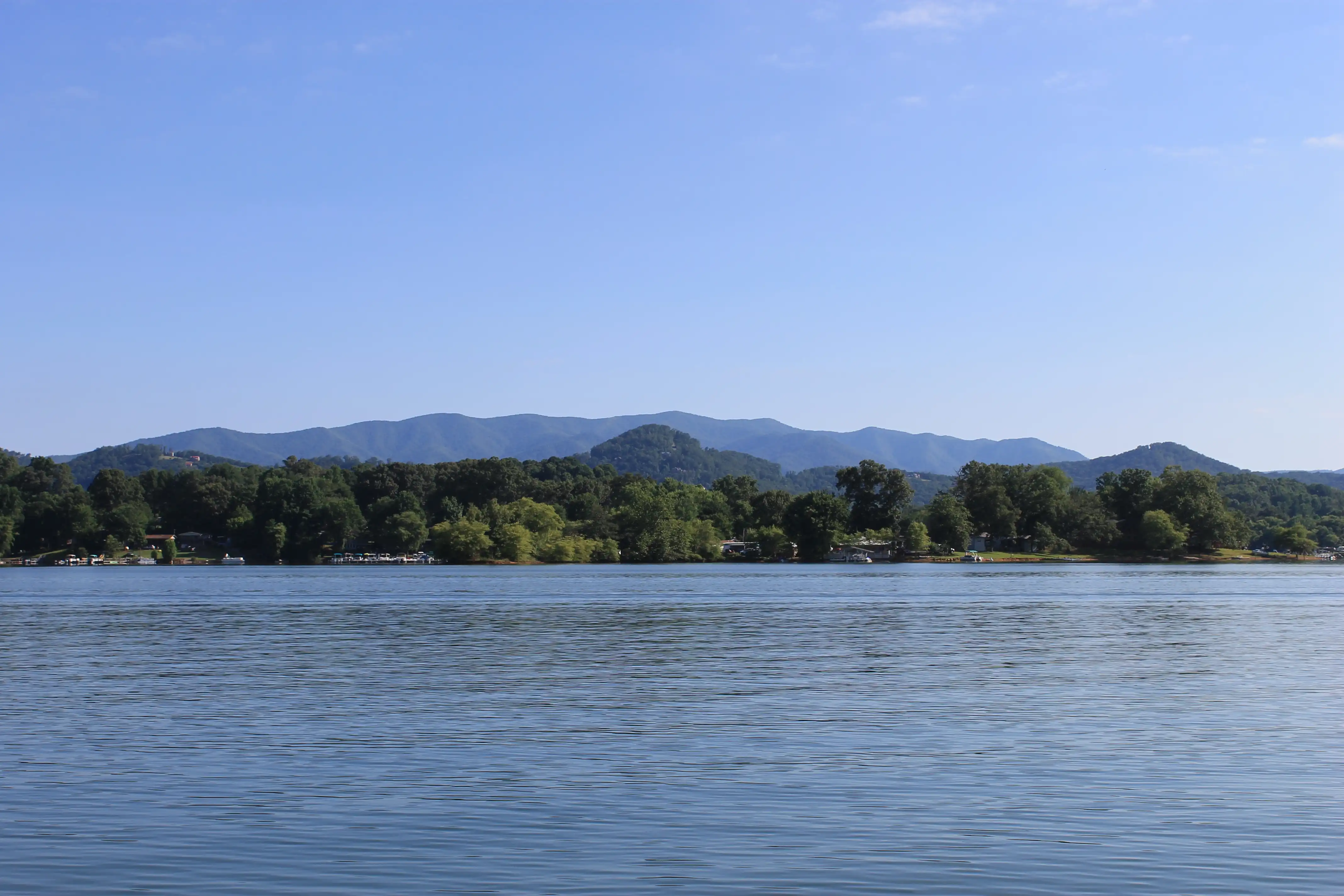 A lake with forested hills in the background