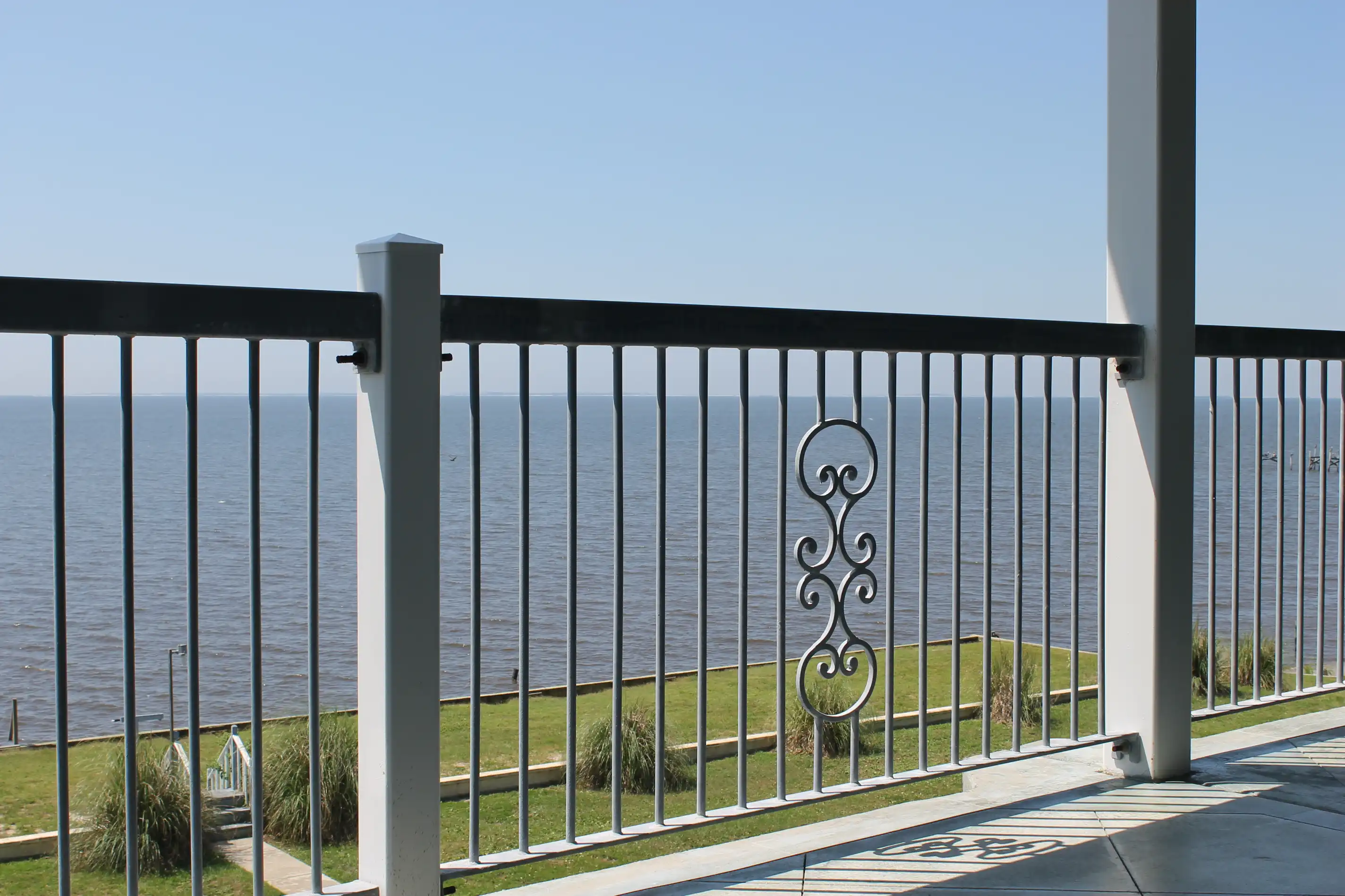 The ocean shot through an old balcony railing