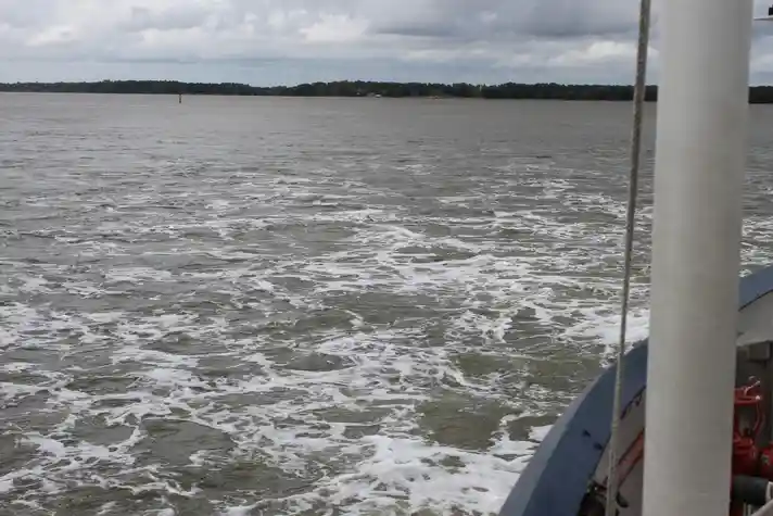 Rough waters on a lake with the shore far in the backdrop