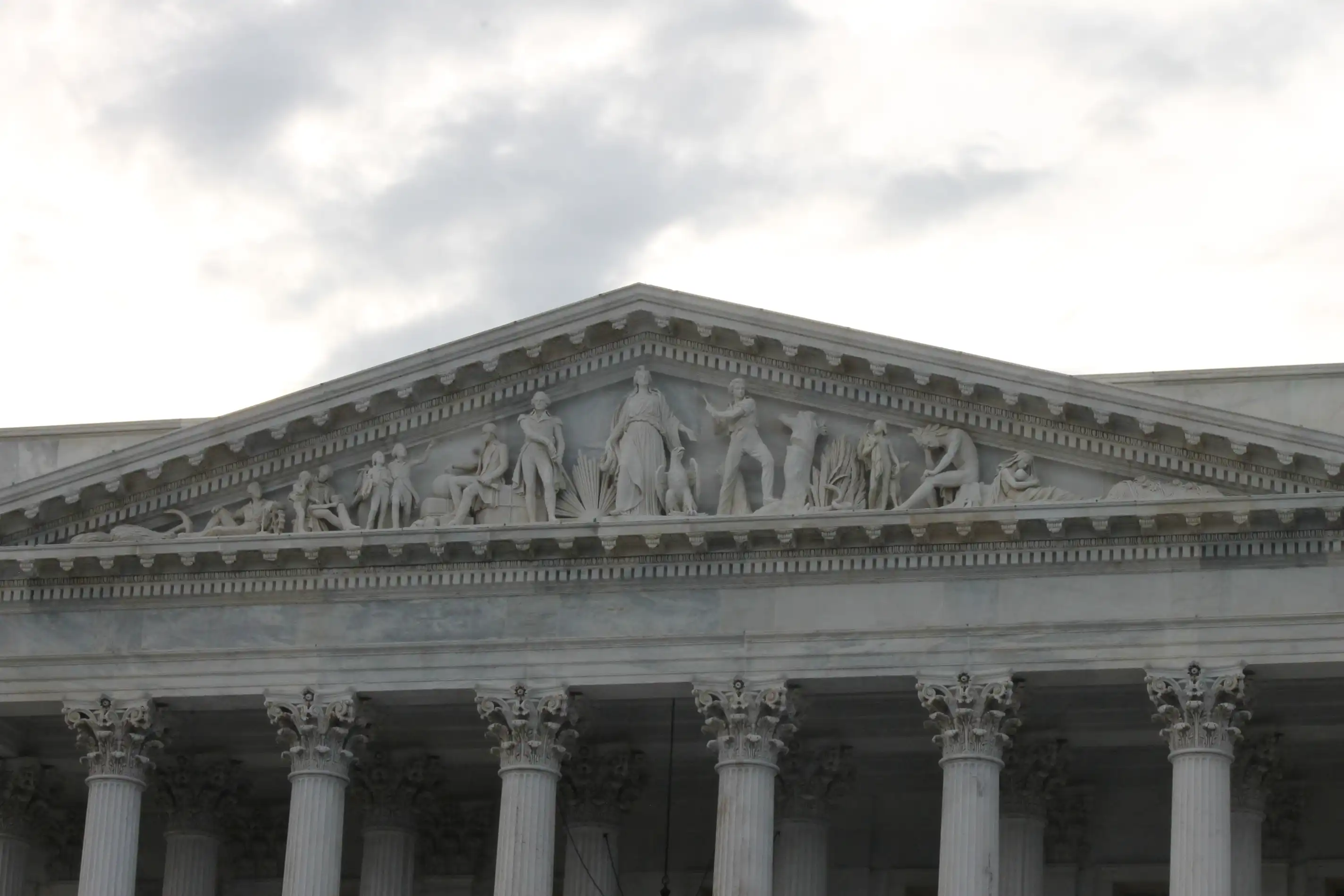 A monument in washington DC with large columns and roman style statues at the top