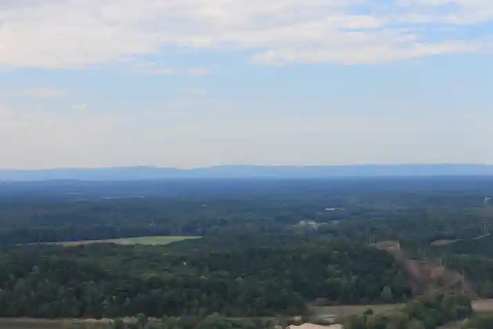 A forest shot from a high vantage point with a large mountain range far in the background